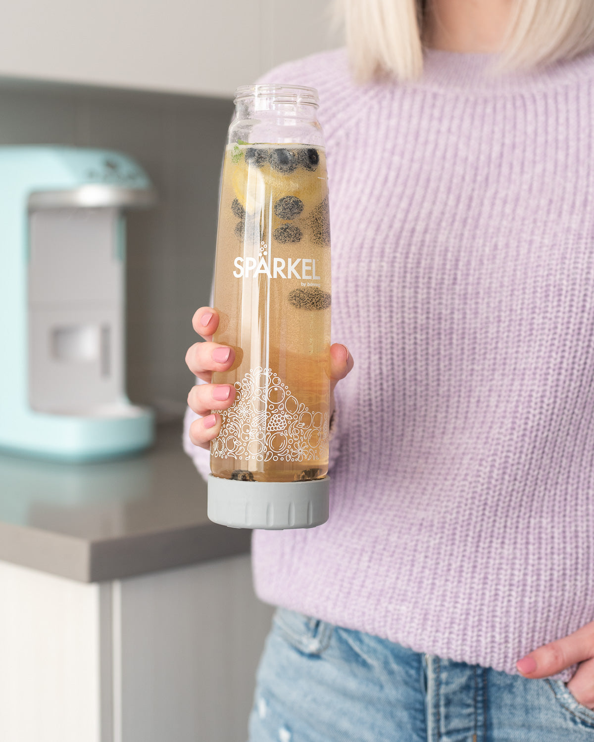 Mom holding a healthy sparkling beverage made with a Spärkel Soda Maker