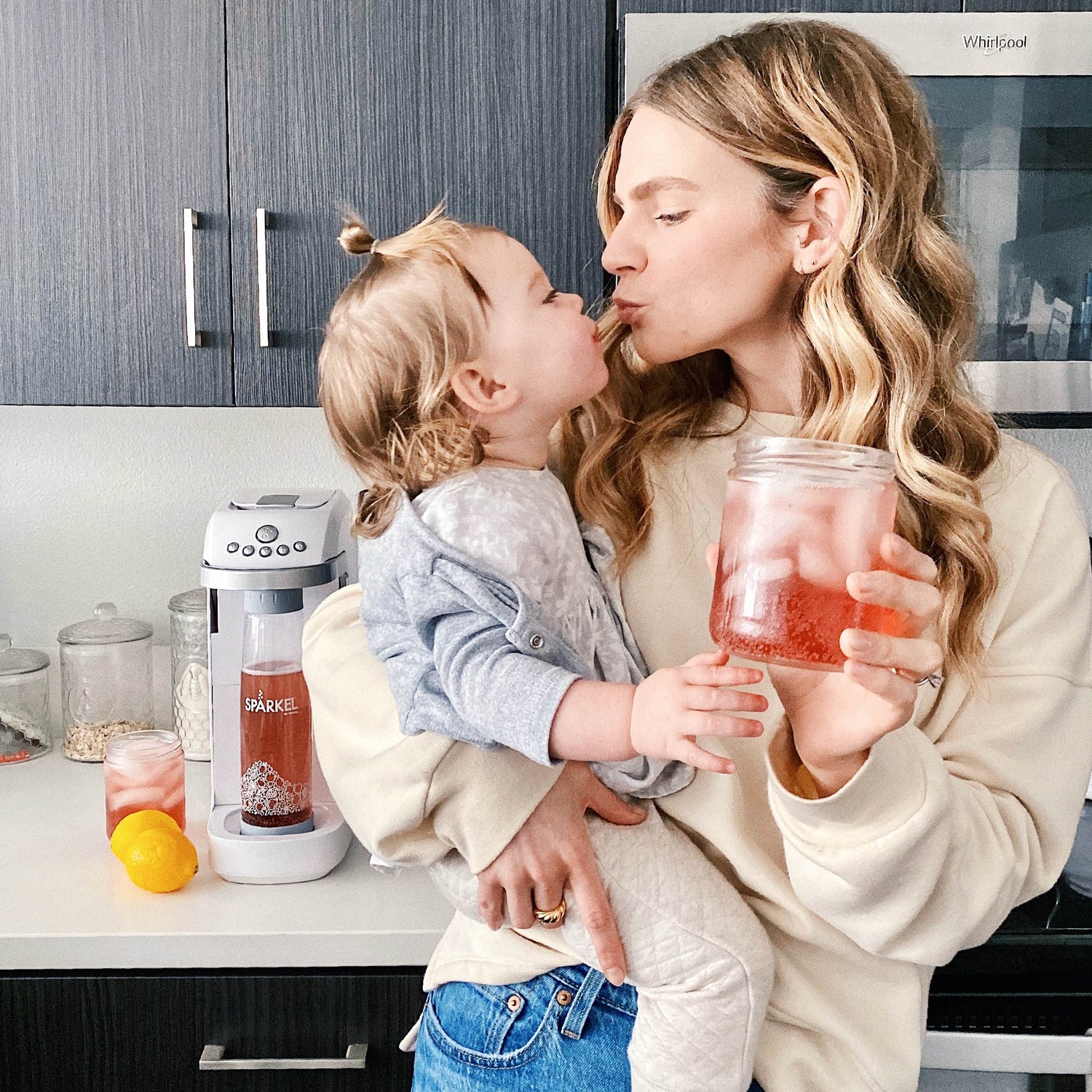 Happy mom with a sparkling juice made with a Spärkel Soda Maker